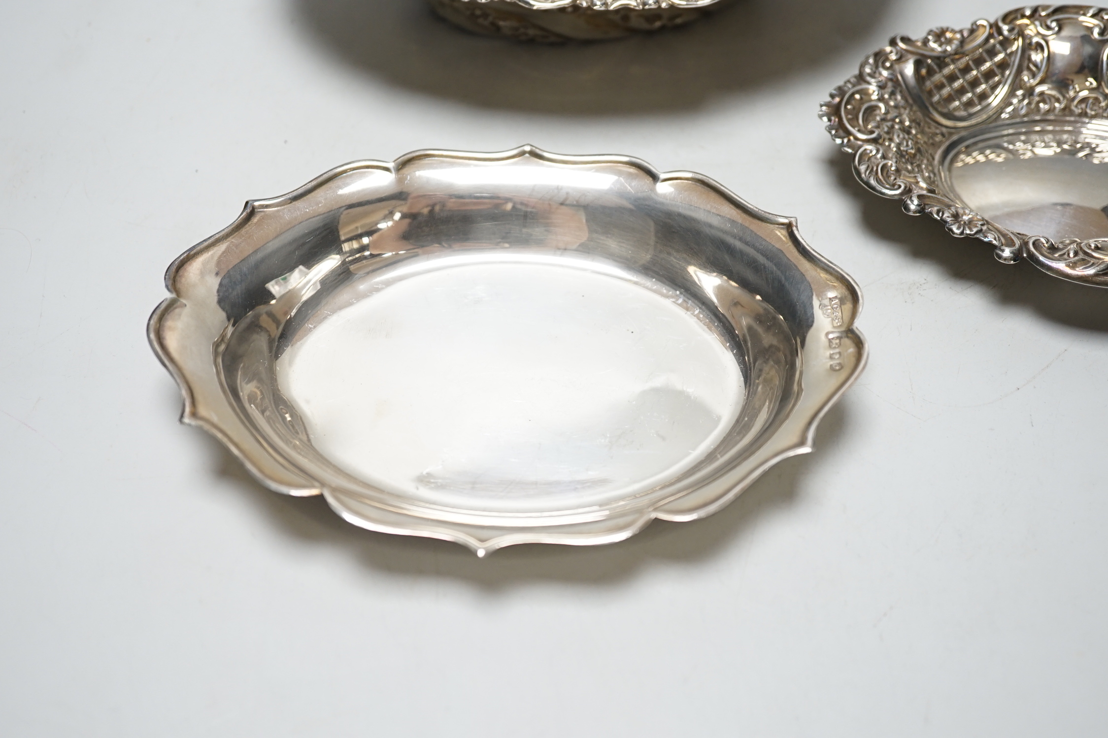 A late Victorian repousse silver oval bowl, William Comyns, London, 1889, 21.1cm and two other smaller silver dishes, 10.8oz.